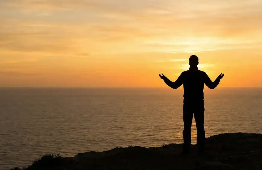 Home 33 Ilustrasi Muslim berdiri di tebing saat senja, mengangkat tangan tanda berserah diri total kepada Rahmat Allah, sesuai doa Abu Bakrah.
