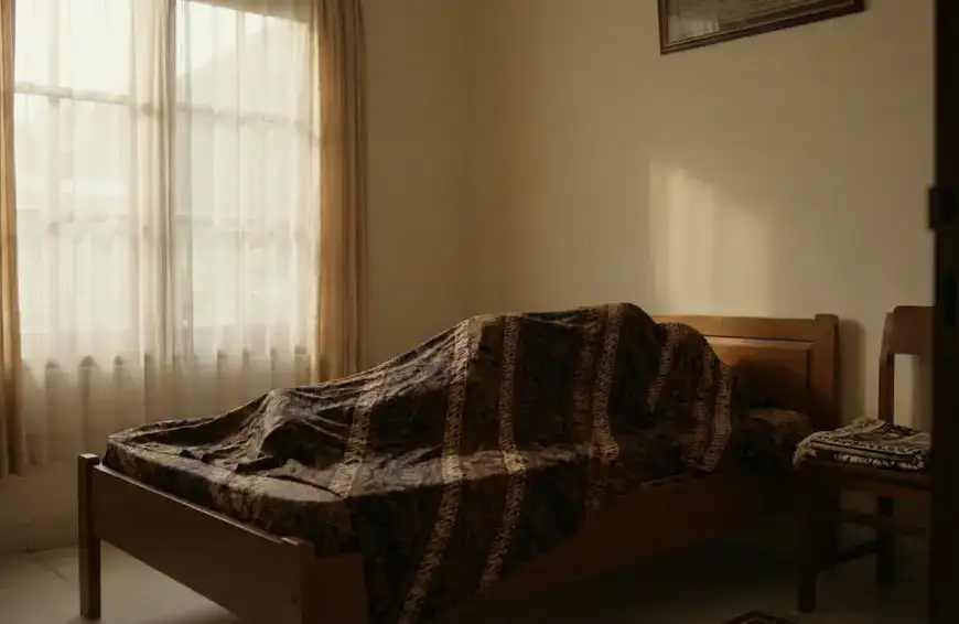 Home 7 Suasana hening di kamar tidur dengan jenazah yang sudah ditutup kain batik panjang dari kepala hingga kaki, ilustrasi persiapan awal merawat jenazah sebelum dimandikan.