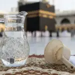 Kendi berisi air zamzam di Masjidil Haram bersanding dengan gayung pembersih, mengilustrasikan hukum fiqih penggunaannya untuk najis.