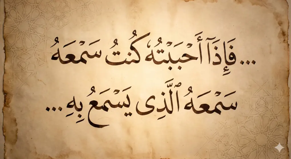 Foto close-up kaligrafi Arab bergaya tsuluts di atas kertas perkamen tua, menampilkan potongan Hadits Qudsi riwayat Bukhari tentang Wali Allah: "...fa idza ahbabtuhu kuntu sam'ahu alladzi yasma'u bihi..."