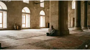 Home 13 A Muslim man sitting silently in a grand mosque, demonstrating the proper etiquette of I'tikaf through quiet contemplation and reverence.