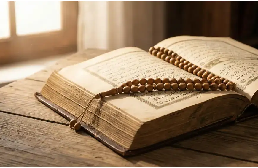 A classic leather-bound Islamic manuscript and a wooden tasbih resting on a desk, representing the traditional knowledge of the etiquette of supplication (dua).