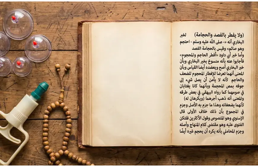 Foto flat lay di atas meja kayu yang menampilkan manuskrip Fiqih Arab antik terbuka yang membahas hukum bekam (hijamah) saat berpuasa, di samping gelas bekam plastik modern, pompa sedot manual, dan tasbih kayu.