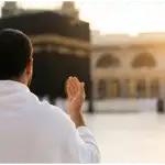 Seorang jamaah pria berdoa dengan khusyuk di depan Ka'bah di Masjidil Haram Makkah saat senja.