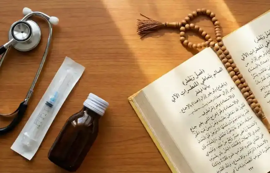 A flat lay view on a wooden table, showing a stethoscope, a sterile syringe, a small brown medicine bottle, an open Arabic Fiqh book (Asna al-Matalib), and a string of prayer bead tasbih.