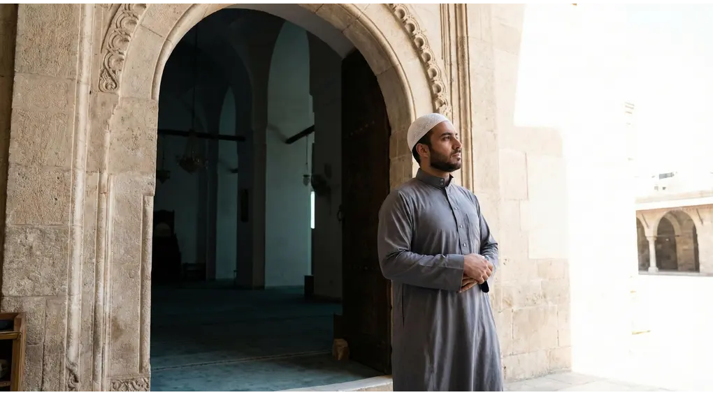 The Valid Conditions and 4 Pillars of I'tikaf in Shafi'i Fiqh 2 A Muslim man pausing at the entrance of a mosque to form his intention before commencing his I'tikaf worship.