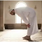 A Muslim man demonstrating the perfect Ruku posture in prayer, featuring a straight back level with the neck and hands grasping the knees.