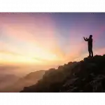 A silhouette of a man making dua at sunrise on a mountain, symbolizing Prophet Adam's sincere repentance and prayer for forgiveness.