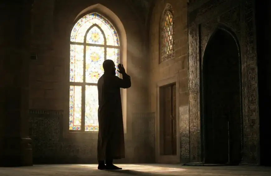Home 13 Silhouette of a Muslim man standing upright raising both hands performing takbiratul ihram inside a mosque illuminated by dramatic morning sunlight.