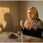 Seorang Muslim berdoa dengan khusyuk di depan kurma dan air putih saat matahari terbenam, menanti waktu berbuka puasa.