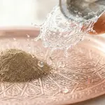 A splash of absolute water and pure earth on a copper tray serving as the primary media for Islamic purification from najis.