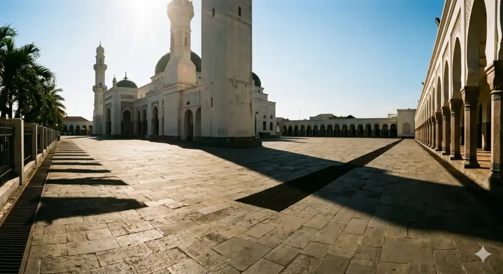Hukum Ibrad: Menunda Shalat Dzuhur saat Cuaca Terik, Sunnah atau Bukan? 1 Halaman masjid di siang hari yang terik dengan bayangan dinding yang memanjang — ilustrasi kondisi ibrad shalat Dzuhur