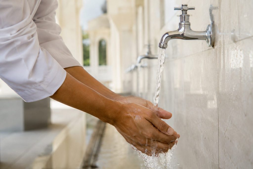 The Wisdom of Thaharah in Islam: Purifying the Body and Soul 4 Washing hands during wudu as a daily example of Islamic purification.